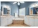 Bathroom featuring a tiled corner tub, dual sinks, and white cabinets at 1721 Bowline Dr, Mount Pleasant, SC 29466