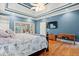 Main bedroom with tray ceiling, hardwood floors, and a view into the sunroom at 1721 Bowline Dr, Mount Pleasant, SC 29466