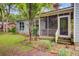 Backyard featuring patio steps, a screened-in porch, and small garden along a tree line at 1830 Kempton Ave, James Island, SC 29412