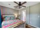 Bedroom featuring ceiling fan, grey walls, white trim, a bed with colorful comforter, and doorway at 1830 Kempton Ave, James Island, SC 29412