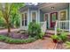 Inviting entryway featuring a brick walkway leading to a red front door and lush landscaping at 1830 Kempton Ave, James Island, SC 29412
