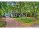 Two-story home with light blue siding, detached garage, mature landscaping, and brick driveway at 1830 Kempton Ave, James Island, SC 29412