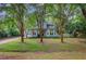Two-story home with light blue siding, bay windows, mature landscaping, and tall crepe myrtle trees at 1830 Kempton Ave, James Island, SC 29412