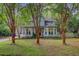 Two-story home with light blue siding, bay windows, mature landscaping, and tall crepe myrtle trees at 1830 Kempton Ave, James Island, SC 29412