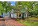 Two-story home with light blue siding, detached garage, mature landscaping, and brick driveway at 1830 Kempton Ave, James Island, SC 29412