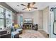 A living room with modern decor, large windows, a ceiling fan, a television, and two chairs at 1830 Kempton Ave, James Island, SC 29412