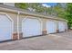 Multiple garages with white doors and brick foundations line up in a row outside the property at 188 Midland Pkwy # 516, Summerville, SC 29485