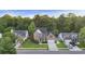 An aerial view showcases this two-story brick home with an attached garage, mature trees and a large lawn at 1901 Bairds Cv, Charleston, SC 29414
