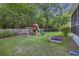 Green backyard featuring a wooden playset, swing, and flower garden at 1901 Bairds Cv, Charleston, SC 29414
