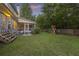 Spacious backyard with lush green grass, screened porch, playset and surrounding trees at 1901 Bairds Cv, Charleston, SC 29414