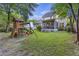 A lawn features a wooden playset, fenced yard, and view of the rear of home at 1901 Bairds Cv, Charleston, SC 29414