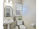 Well-lit powder room with pedestal sink, toilet, and classic fixtures at 1901 Bairds Cv, Charleston, SC 29414