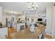 Open concept dining room with chandelier, wooden table, and access to the kitchen and living area at 1901 Bairds Cv, Charleston, SC 29414