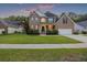 Beautiful two-story brick home with well-kept lawn, inviting front porch and exterior lighting at 1901 Bairds Cv, Charleston, SC 29414
