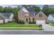 Brick home featuring an attached two-car garage, front lawn, and mature landscaping at 1901 Bairds Cv, Charleston, SC 29414