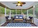 Inviting screened porch with cozy blue seating, ceiling fan, and view of the backyard at 1901 Bairds Cv, Charleston, SC 29414