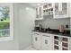 Modern bar area with white cabinets, a wine rack, granite counters, and a coffee machine at 197 High Grove Rd, Summerville, SC 29485