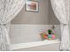 Close up of a soaking bathtub with decorative curtains and coordinating elements at 197 High Grove Rd, Summerville, SC 29485