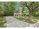 A charming two-story white house with a long driveway and well-maintained lawn surrounded by mature trees at 197 High Grove Rd, Summerville, SC 29485