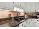 Modern kitchen features a black sink, stylish backsplash, and white cabinets, perfect for culinary enthusiasts at 197 High Grove Rd, Summerville, SC 29485