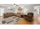 Spacious living room featuring neutral walls, a ceiling fan, wood floors, and comfortable brown sofas at 197 High Grove Rd, Summerville, SC 29485