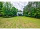 Expansive backyard with lush green grass, mature trees and potential for outdoor activities with a view of the house at 1976 Liberia Rd, Wadmalaw Island, SC 29487