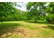 Large backyard with a volleyball net surrounded by mature trees at 1976 Liberia Rd, Wadmalaw Island, SC 29487