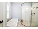 The bathroom features a soaking tub, white subway tile shower, and brass fixtures at 1976 Liberia Rd, Wadmalaw Island, SC 29487
