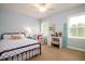 Bright bedroom features a bed, desk, sitting chair, and two windows at 1976 Liberia Rd, Wadmalaw Island, SC 29487