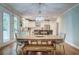 Open-concept dining area with hardwood floors and a chandelier flowing into the kitchen with stainless steel appliances at 1976 Liberia Rd, Wadmalaw Island, SC 29487