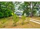 Charming two-story home with lush landscaping and mature trees in the front yard at 1976 Liberia Rd, Wadmalaw Island, SC 29487