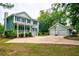 Two-story home with detached garage and basketball hoop; spacious driveway at 1976 Liberia Rd, Wadmalaw Island, SC 29487
