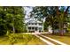 Charming two-story home with a welcoming front porch, manicured lawn, mature trees, and a circular driveway at 1976 Liberia Rd, Wadmalaw Island, SC 29487
