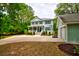 Beautiful two-story home with a classic design, inviting front porch, lush landscaping, and a detached garage at 1976 Liberia Rd, Wadmalaw Island, SC 29487