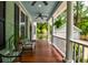 Inviting front porch with ceiling fans, potted plants and seating at 1976 Liberia Rd, Wadmalaw Island, SC 29487