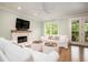 Bright living room with a fireplace, white sofas, and french doors at 1976 Liberia Rd, Wadmalaw Island, SC 29487
