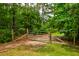Equestrian property entrance featuring a metal gate between wooden posts surrounded by lush greenery at 1976 Liberia Rd, Wadmalaw Island, SC 29487
