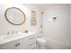 Well-lit bathroom with a large round mirror, white vanity, and tiled shower-tub combination at 2011 N Highway 17 # 2300F, Mount Pleasant, SC 29466