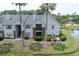 Condominium building surrounded by lush landscaping and a pond with mature palm trees at 2011 N Highway 17 # 2300F, Mount Pleasant, SC 29466