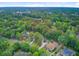 This aerial view showcases a neighborhood with mature trees and various styles of homes nestled among the foliage at 2076 Rookery Ln, Charleston, SC 29414