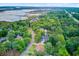 Aerial view capturing homes and lush greenery alongside a tranquil bay area with a pier in the distance at 2076 Rookery Ln, Charleston, SC 29414