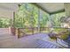 Relaxing back porch with wood floors, railing, and comfortable seating with serene views of the surrounding nature at 2076 Rookery Ln, Charleston, SC 29414