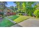 Lush backyard featuring a well-manicured lawn, a concrete patio, mature trees, and a charming back porch at 2076 Rookery Ln, Charleston, SC 29414