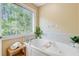A well-lit bathroom with a soaking tub and large window with natural light at 2076 Rookery Ln, Charleston, SC 29414