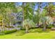Charming two-story home with a cozy front porch, lush lawn, mature palm trees, and white picket fence at 2076 Rookery Ln, Charleston, SC 29414