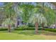 Charming two-story home with a cozy front porch, lush lawn, mature palm trees, and white picket fence at 2076 Rookery Ln, Charleston, SC 29414