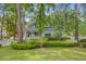 Charming two-story home with a cozy front porch, manicured lawn, mature trees, and white picket fence at 2076 Rookery Ln, Charleston, SC 29414