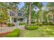 Charming two-story home with a welcoming front porch, lush landscaping, and a white picket fence at 2076 Rookery Ln, Charleston, SC 29414