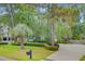 Inviting two-story home with a well-manicured lawn, mature trees, a palm and a white picket fence at 2076 Rookery Ln, Charleston, SC 29414