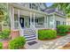 Inviting front porch with a porch swing, white railings, and a beautifully decorated entryway at 2076 Rookery Ln, Charleston, SC 29414